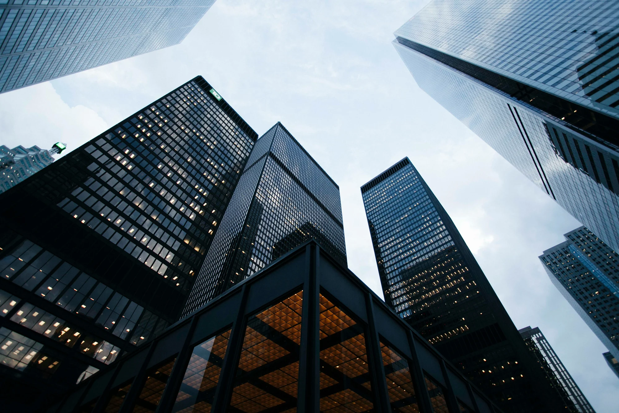 Glass office towers photographed from their central plaza.